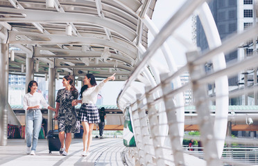 Happy group of tourists traveling and shopping while walking in the city. Multiethnic friend Smiling is exploring new city together. Asia tourism,holiday vacation travel concept.