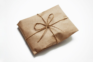 Wrapping brown craft paper package with hemp as present. Hand made parcel bag gift. Isolated on white background.