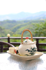 teapot with tea cups with fresh natural background concept of relaxing and breaking time