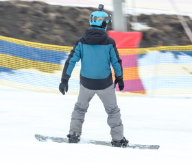 A guy is riding a snowboard from a mountain in winter
