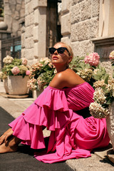 woman with blond hair in luxurious pink dress, having summer vacation in Europe - 229705789
