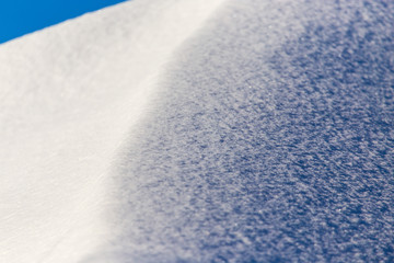 White snow against the blue sky as a background