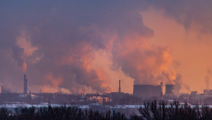 Smoke from the factory pipes against the dawn of the sun