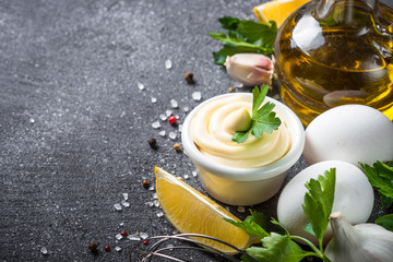 Mayonnaise sauce on black stone table. 