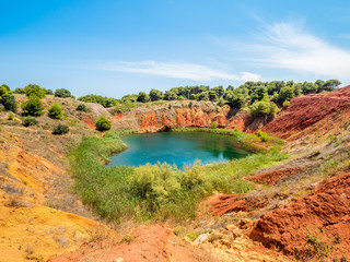 The lake in a old bauxite's red soils quarry cave in Apulia, Otranto, Salento, Italy. The digging...
