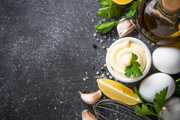 Mayonnaise sauce on black stone table. 