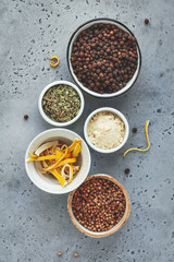 Various spice in bowls on a grey textured background. Top view.