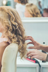 Naklejka premium Hairdressing services. Сreating hairstyle. Hair styling process. Children's hairdressing salon.