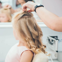 Fototapeta premium Hairdressing services. Сreating hairstyle. Hair styling process. Children's hairdressing salon.