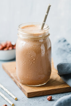 Nut butter chocolate protein shake in a glass jar. The concept of a healthy lifestyle and fitness diet.