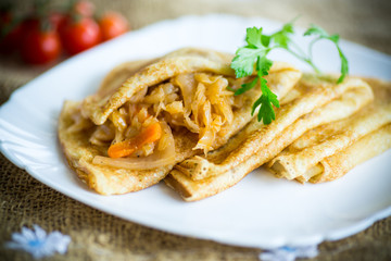 thin fried pancakes stuffed with stewed cabbage in a plate