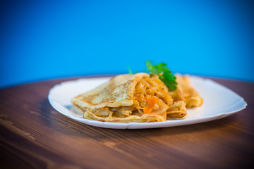 thin fried pancakes stuffed with stewed cabbage in a plate