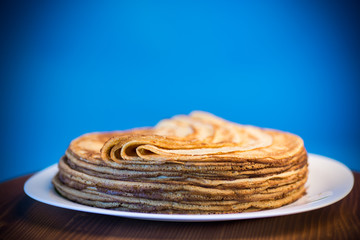 big high stack of thin pancakes in a plate
