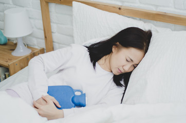 Asian girl has abdominal pain. Embrace to relieve symptoms.The girl suffered severe pain. When is...