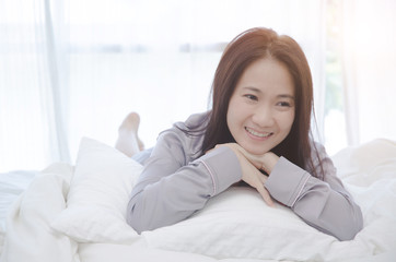 Beautiful woman sleeping in the bedroom. Asian women sleep well.Sleeping in a white room makes you feel comfortable. Warm tone.