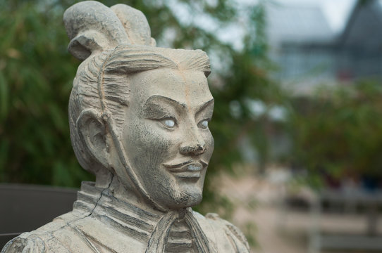 closeup of stoned statue in japanese garden