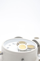 Close up .Alarm clock on white mattress.The Thai Baht currency is on the alarm clock in time concept with saving money.copy space.
