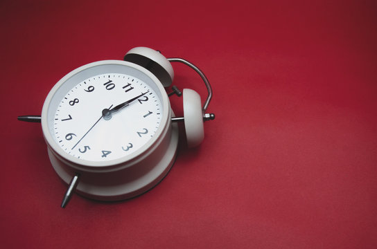 Close up.White Alarm Clock isolated Placed on a red background.copy space.