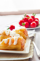 Stuffed pepper with meat and rice on a white square plate