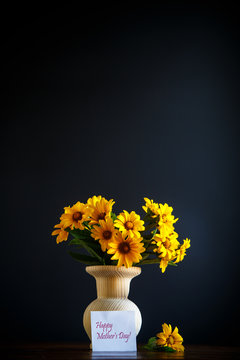 bouquet of yellow big daisies on a black