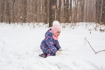 Childhood and nature concept - Adorable child playing in winter park