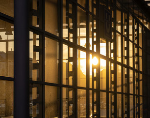 Reflection of the setting sun in the fully glazed facade of a high-rise building.
