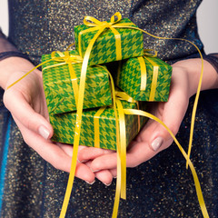 idea of a minimal concept, a girl in a beautiful dress holds many small gifts, hands and gifts close-up