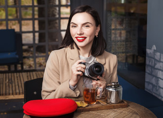 Beautiful young smiling girl with a camera