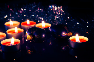 Two violet hearts and Christmas candles atmospheric lights on a blurred background with bokeh effect. Christmas and New Year holiday background concept. Copy space for text.