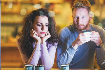 Young attractive couple having problems on date