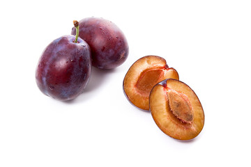 Group of whole and half of ripe plums isolated on a white background..