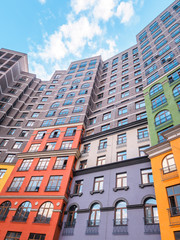 Fototapeta na wymiar Large residential apartment building with colored facades bottom up view