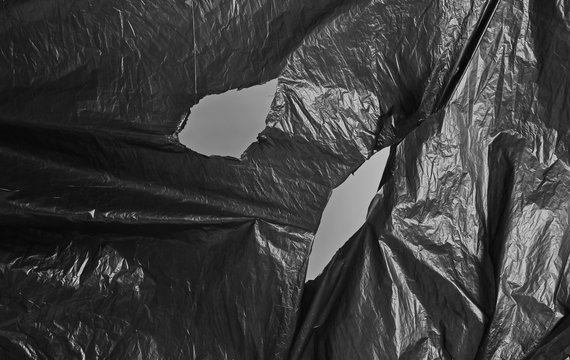 Torn and cut scary black nylon bag background and texture 