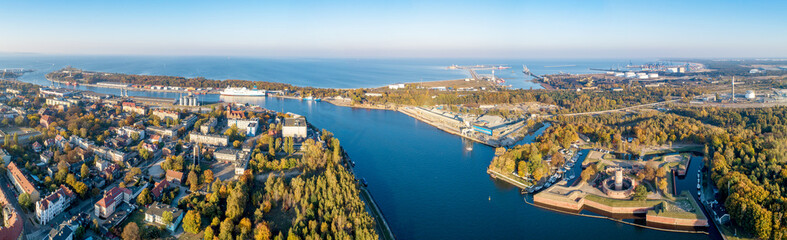 Gdansk, Poland. Wide panorama with Westerplatte peninsula, medieval Wisloujscie Fortress, Dead Vistula river mouth and Exterior Northern Port of Gdansk in the background. Aerial view in sunset light