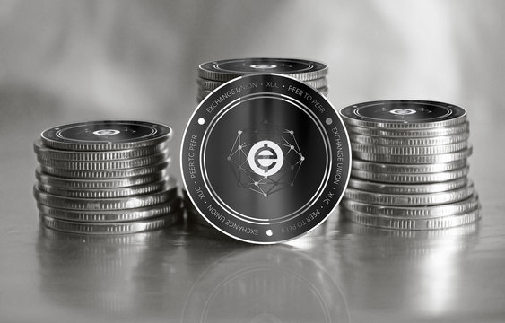 Exchange Union (XUC) digital crypto currency. Stack of black and silver coins. Cyber money.