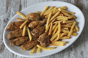 piatto ovale ali di pollo arrosto con patatine fritte dall'alto