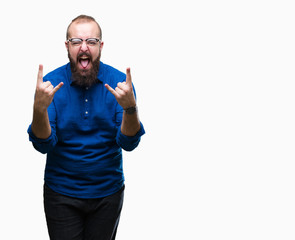 Fototapeta premium Młody hipster kaukaski mężczyzna w okularach na białym tle krzycząc z szalonym wyrazem robi symbol rocka rękami do góry. Gwiazda muzyki. Ciężka koncepcja.