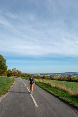 Woman walking on country road - 229717517