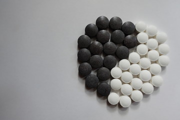 Chelated iron (black) and vitamin K (white) pills in shape of yin and yang symbol