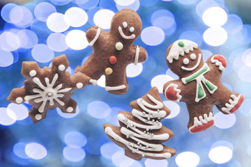 Gingerbread on blue christmas lights background. The concept of celebrating Christmas and New Year.