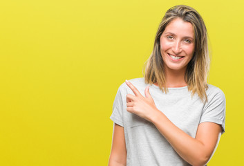 Young beautiful woman over isolated background cheerful with a smile of face pointing with hand and finger up to the side with happy and natural expression on face looking at the camera.