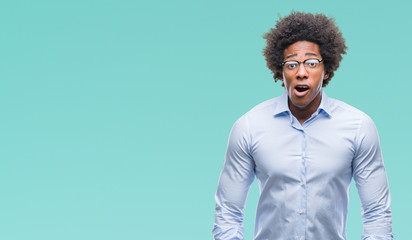 Afro american business man wearing glasses over isolated background afraid and shocked with surprise expression, fear and excited face.