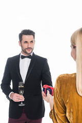 partial view of man with glass of champagne presenting gift to girlfriend isolated on white
