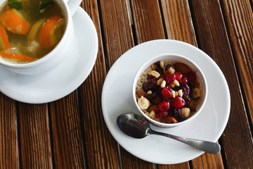 healthy breakfast: oatmeal with dried fruits, nuts and honey and a cup of hot citrus tea