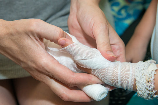 The pregnant mother tending her son's hand