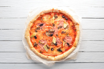 Pizza Caprichos. Bacon, mushrooms, artichokes, tomatoes. Italian traditional dish. On the old background. Top view. Free space for your text.