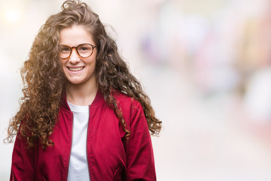 Beautiful brunette curly hair young girl wearing jacket and glasses over isolated background with a happy and cool smile on face. Lucky person.