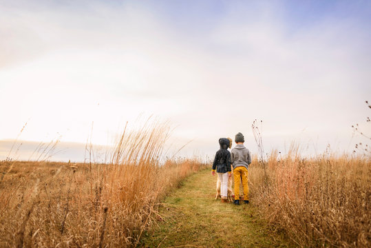 Portrait of a boy and girl standing in a field, United States - Powered by Adobe