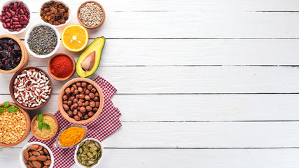 Superfoods Healthy food. Nuts, berries, fruits, and legumes. On a white wooden background. Top...