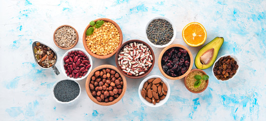 Healthy food. Superfoods Nuts, berries, fruits, and legumes. On a white stone background. Top view. Free copy space.
